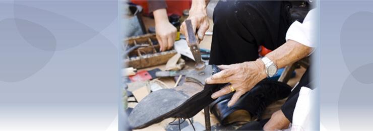 Photo of elderly man repairing a shoe