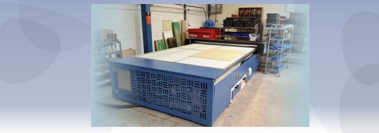 Large banner photo of a cutting unit in a factory with a light blue background