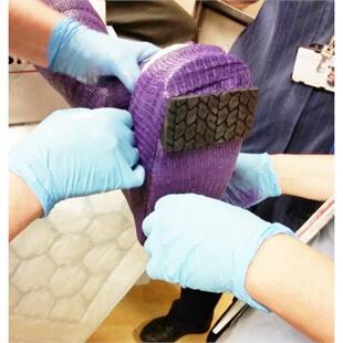 view of black castor soles being fitted onto someones cast
