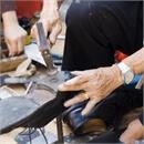 Small photo of elderly man repairing a shoe
